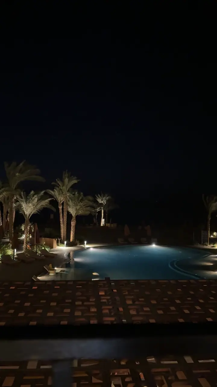 Piscine éclairée la nuit à El Gouna, entre les palmiers