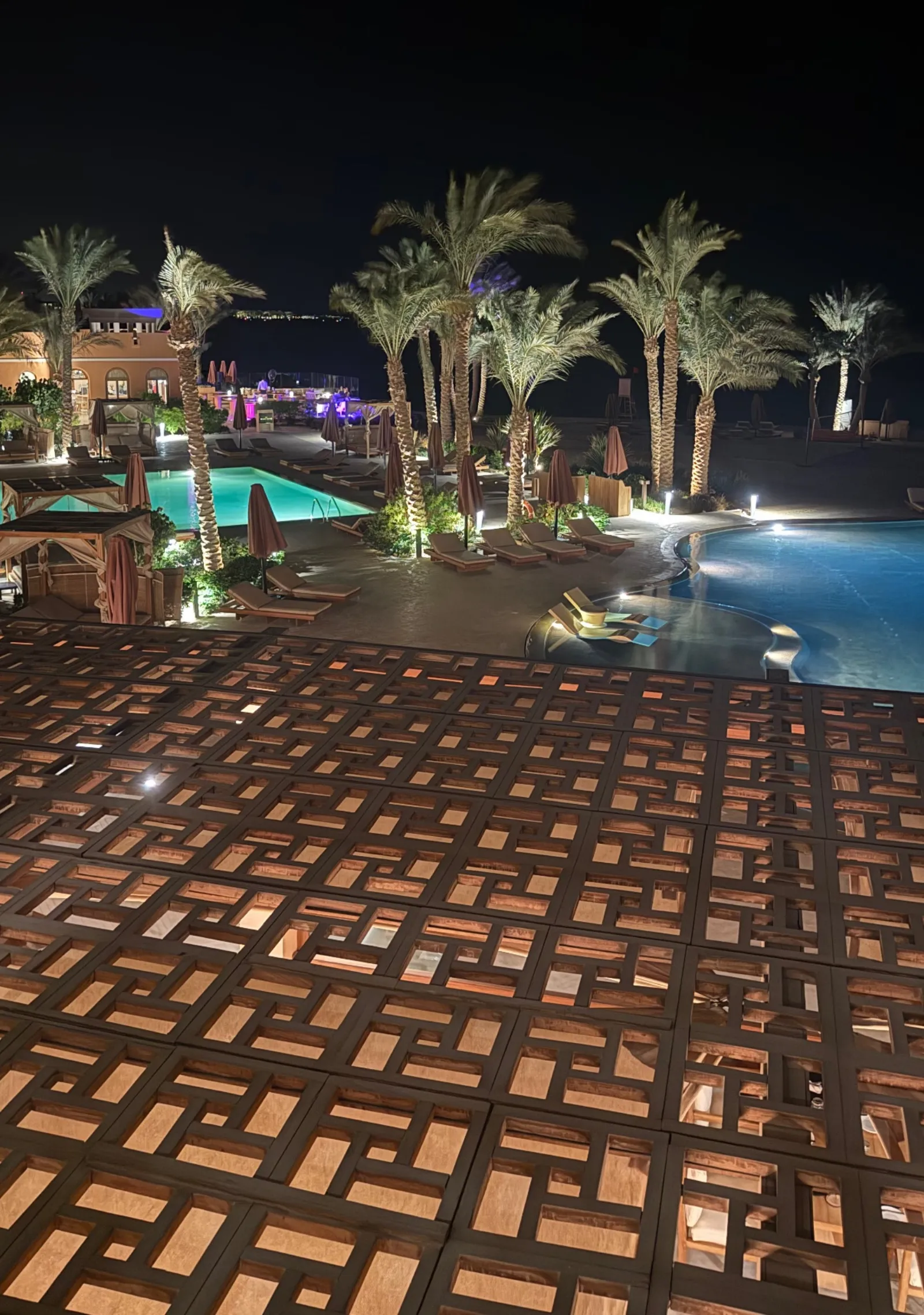 Piscines éclairées la nuit entre les palmiers à El Gouna, près de Hurghada