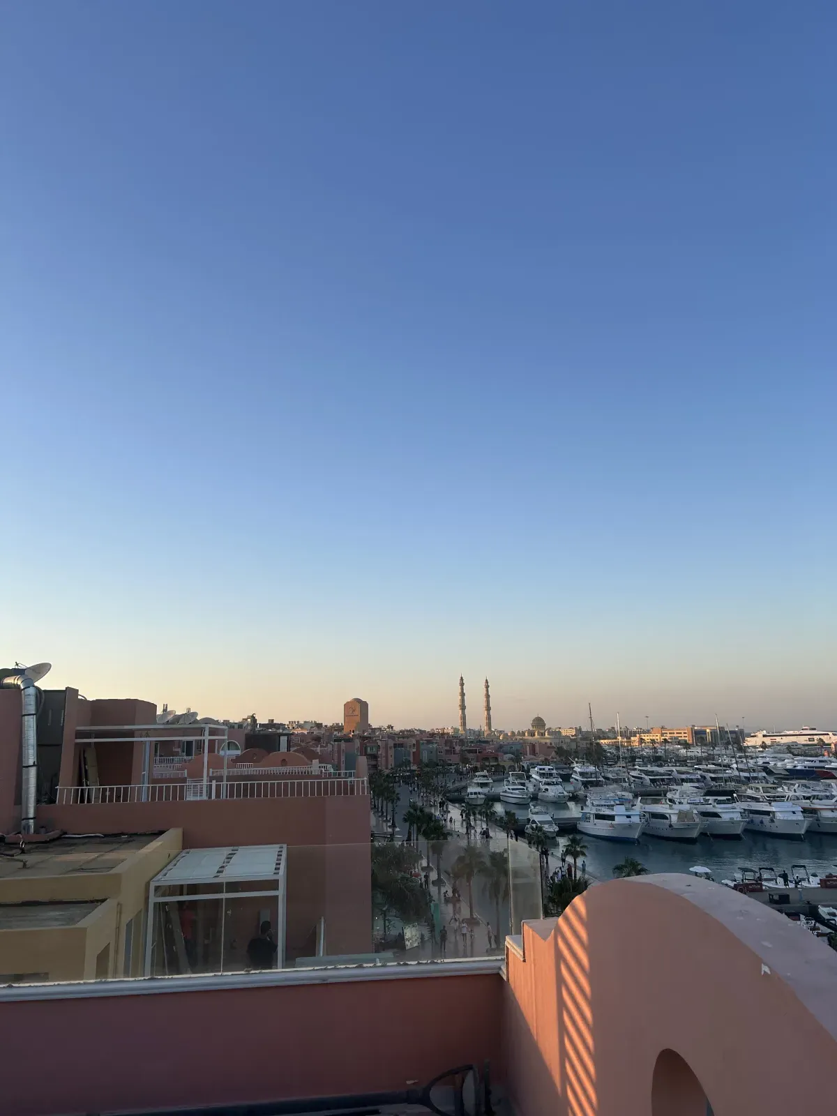 Vue depuis le rooftop privé de la Marina de Hurghada sur les yachts, la promenade et les minarets de la mosquée El Mina, en fin de journée