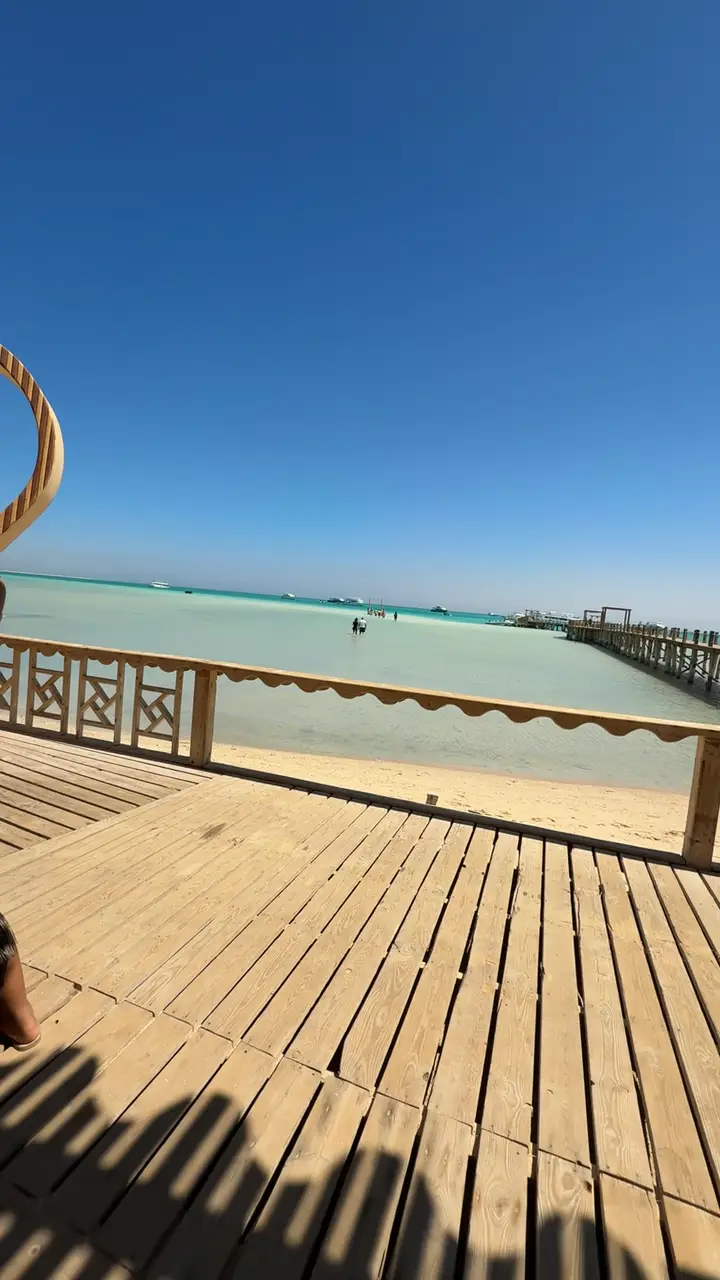 Ponton en bois menant à une plage de sable clair sur une île de la mer Rouge