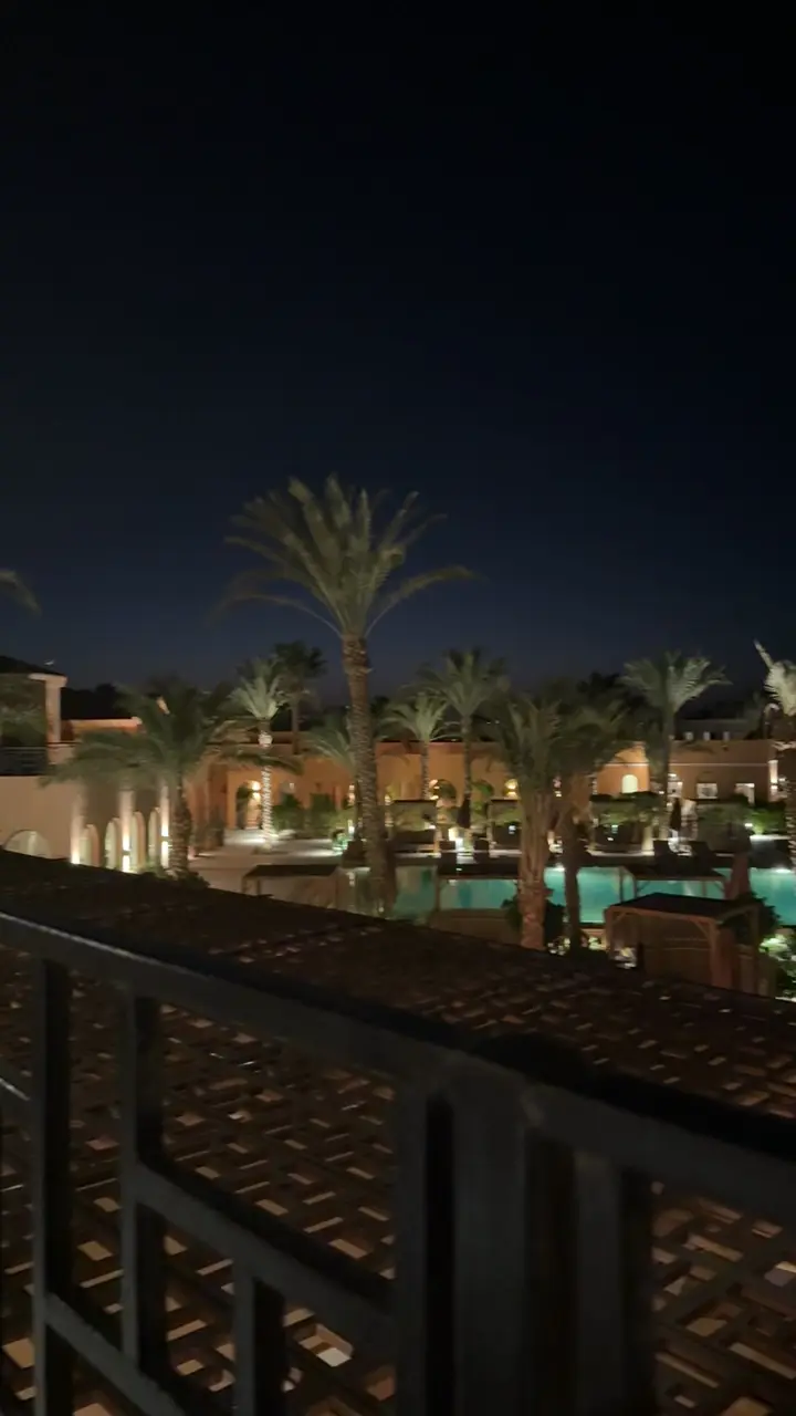 Terrasse éclairée le soir sous les palmiers