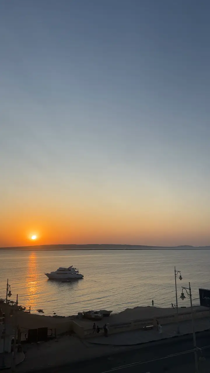 Soleil couchant sur la mer Rouge au large de Hurghada, un bateau en silhouette
